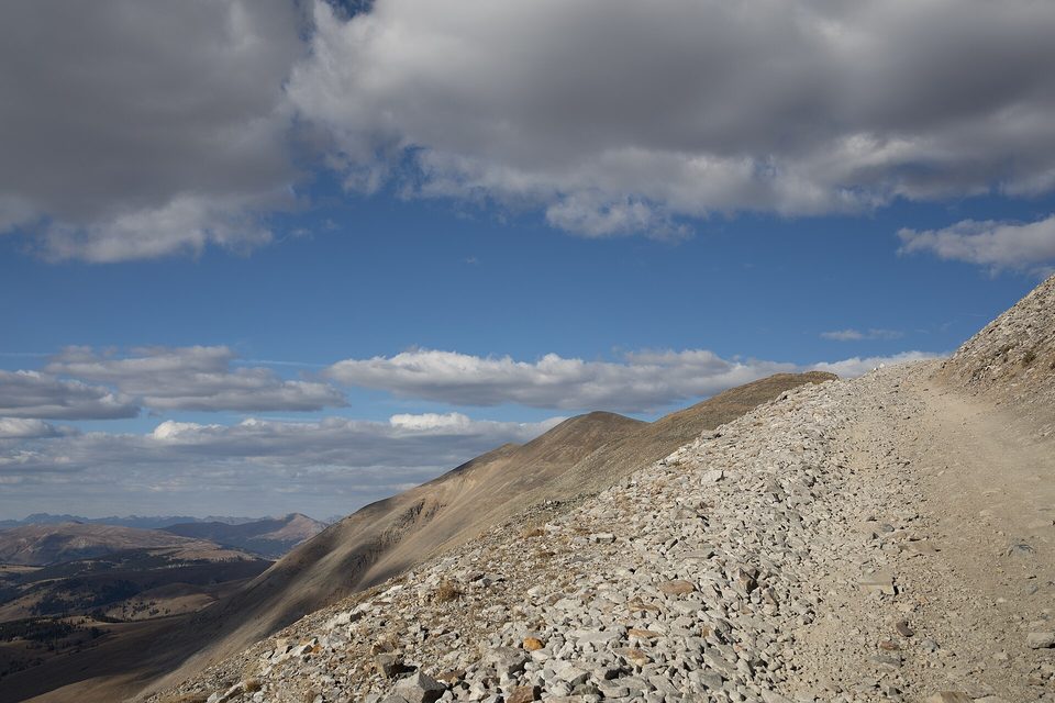 A rocky jeep road climbing along a barren ridge above treeline toward Mosquito Pass